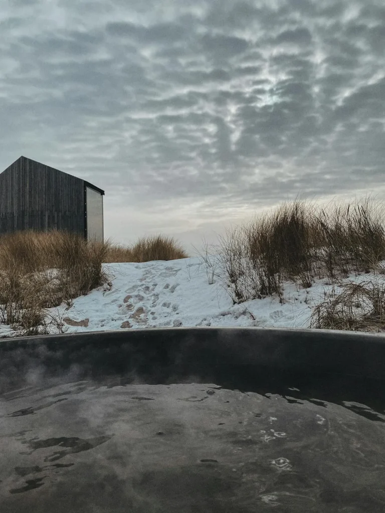 Steaming outdoor hot tub in a snowy winter landscape — how to insulate your hot tub