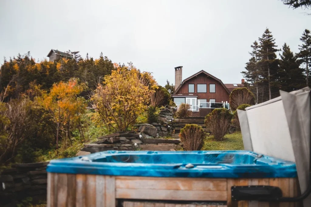 Covered hot tub in front of a countryside cottage during autumn — hot tub chemicals guide