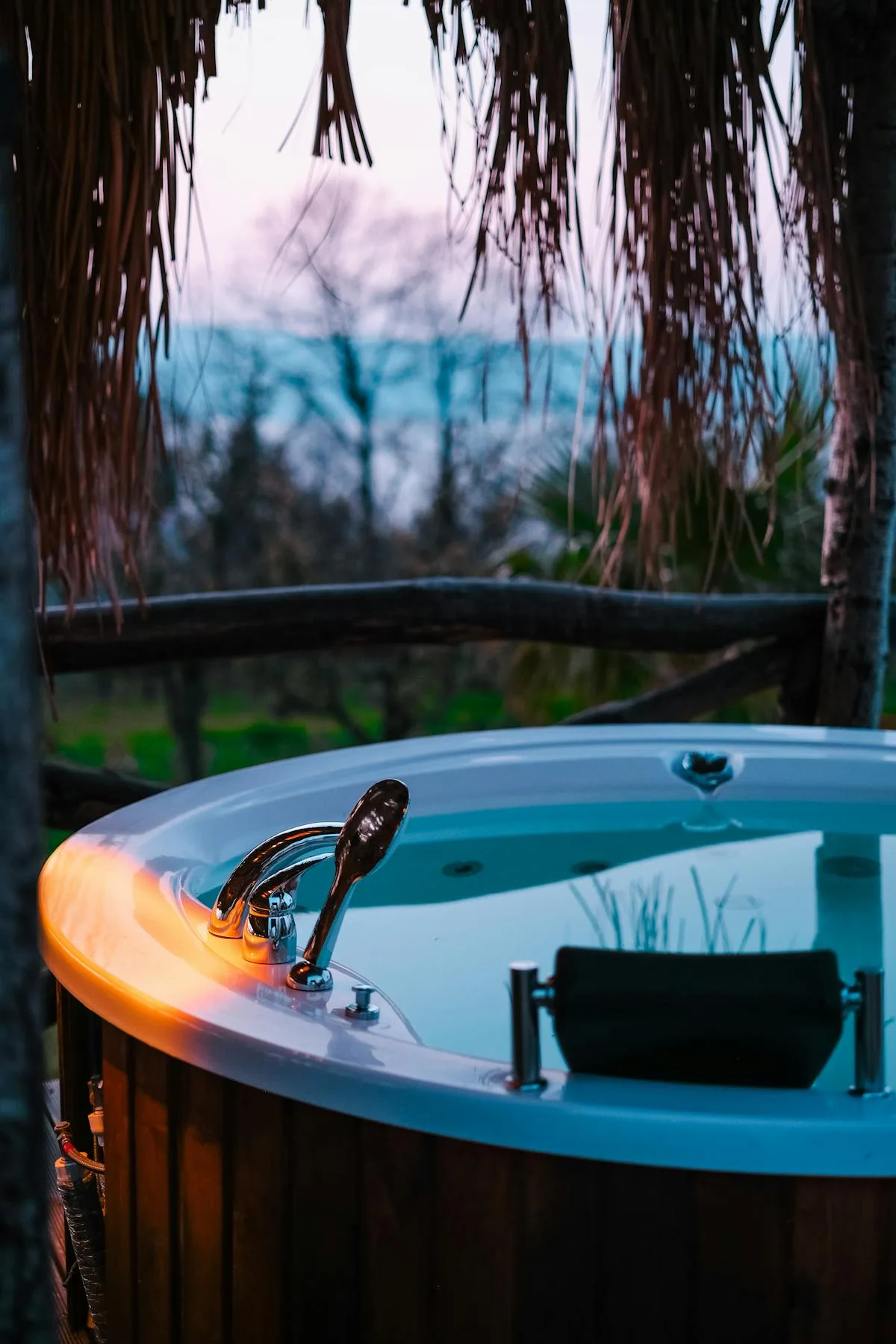 Charming rustic cabin exterior with a vintage wooden hot tub in a lush outdoor setting.