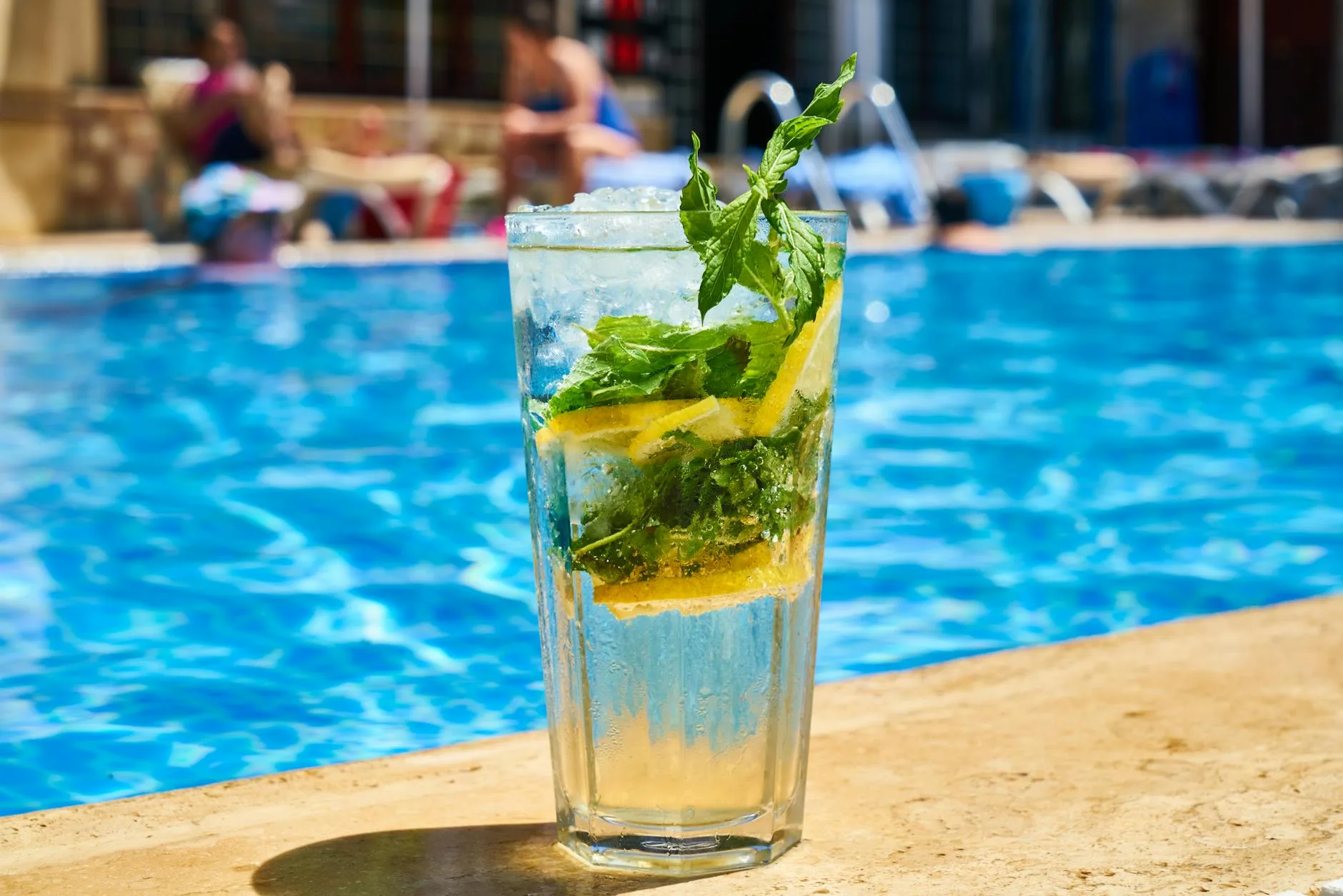 Glass of drink sitting on the edge of a spa pool