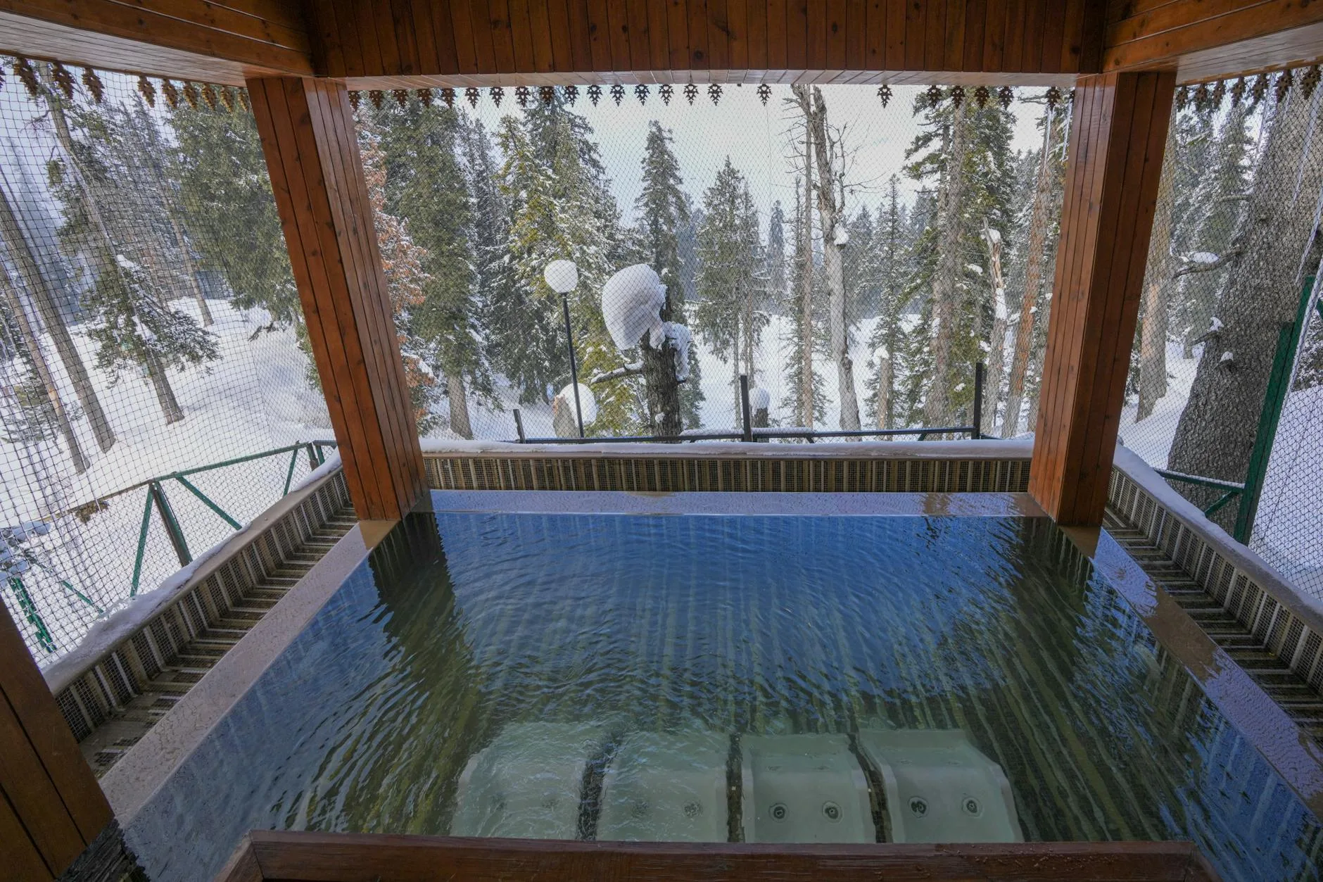 Hot tub with protective cover in a snowy winter garden