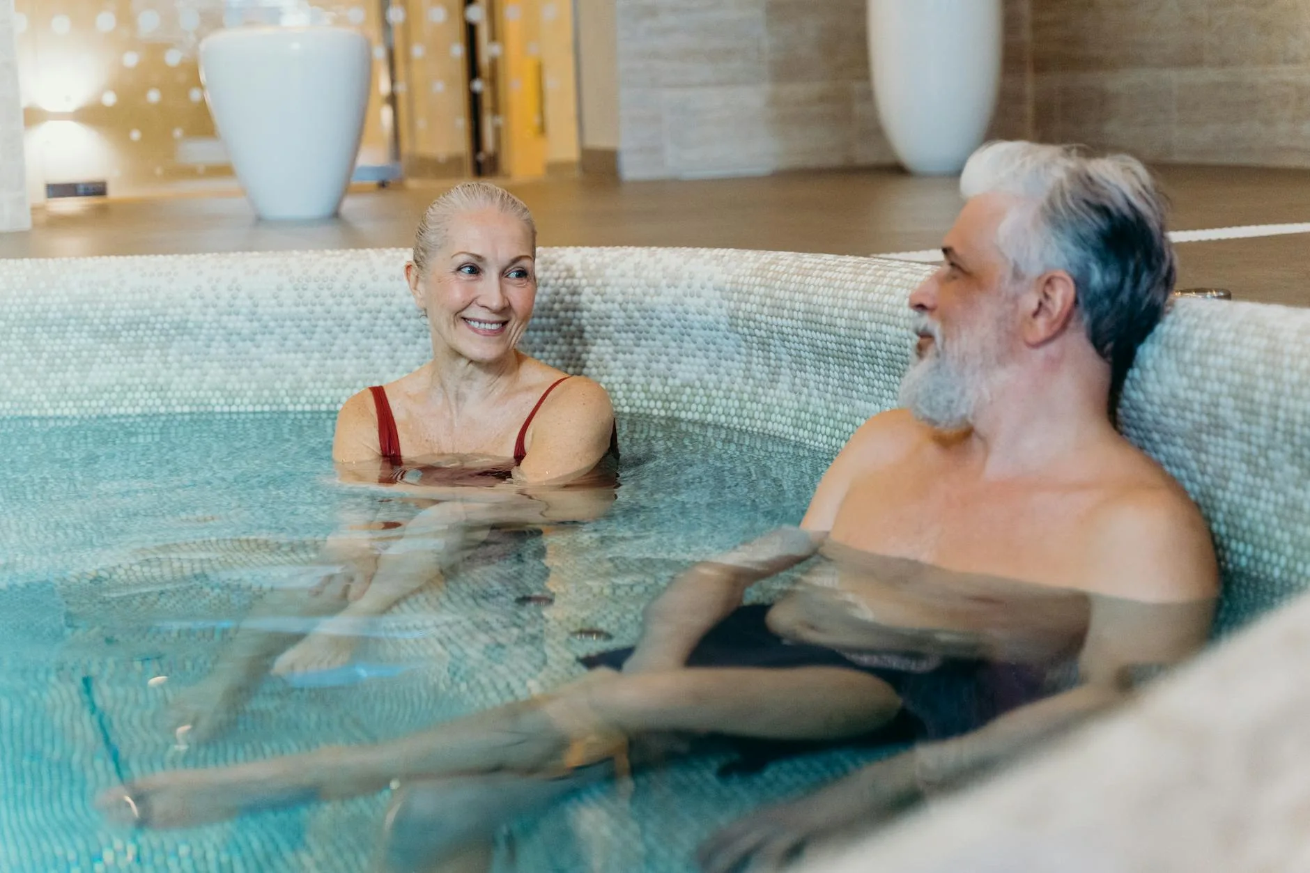 Outdoor spa with warm bubbling water on a garden deck