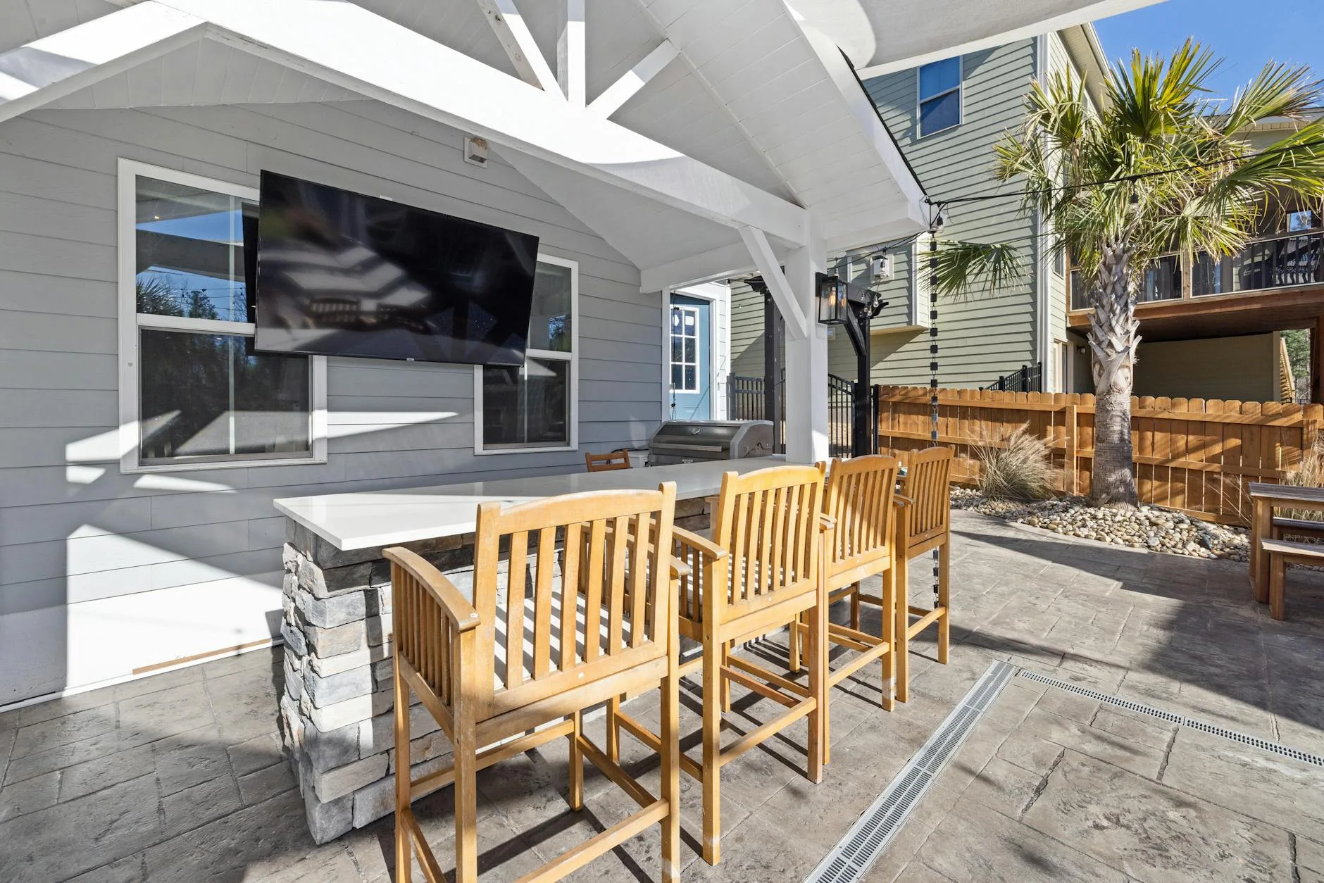 Outdoor television mounted on patio near garden seating