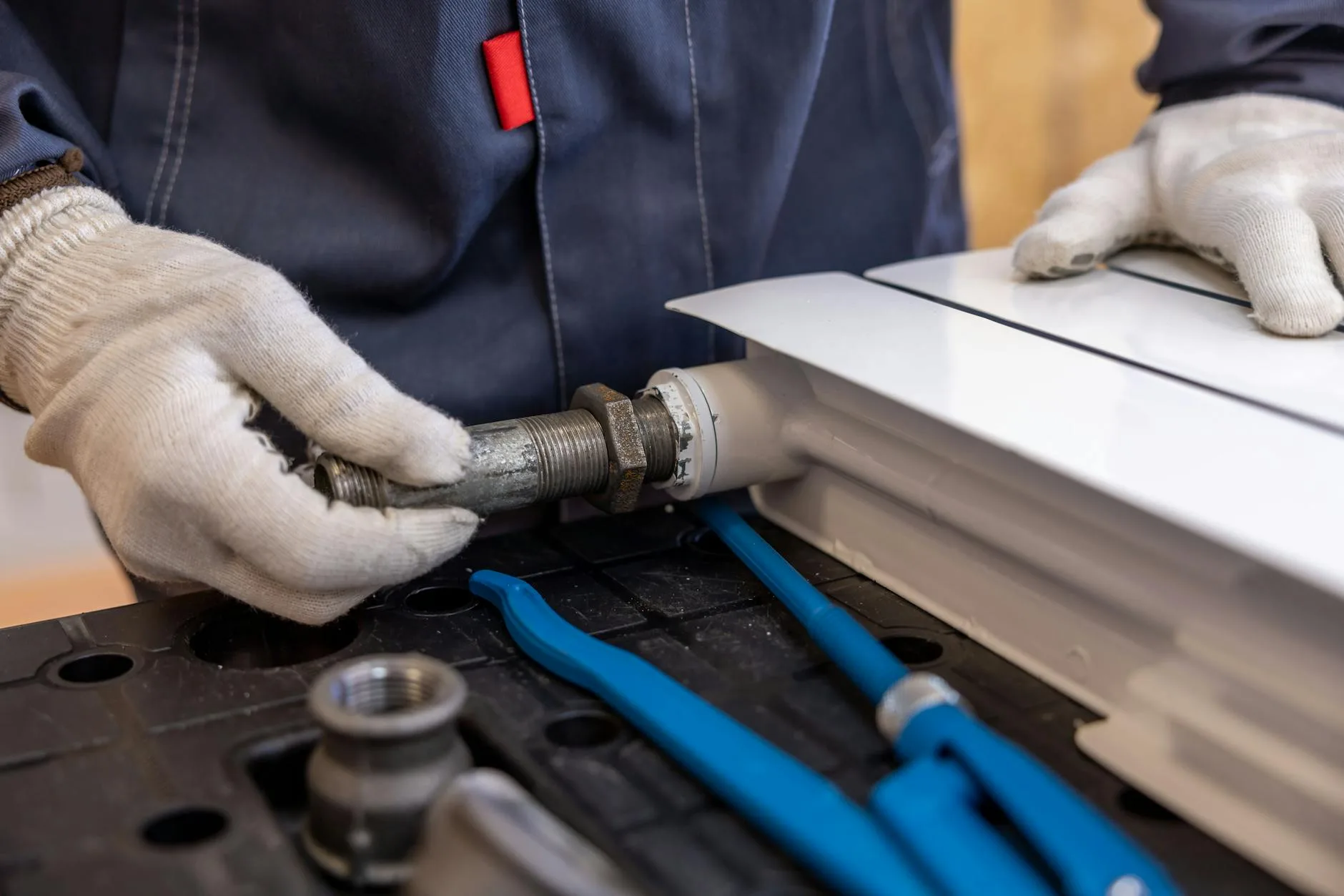 Plumber tightening a pipe fitting with a wrench during repair