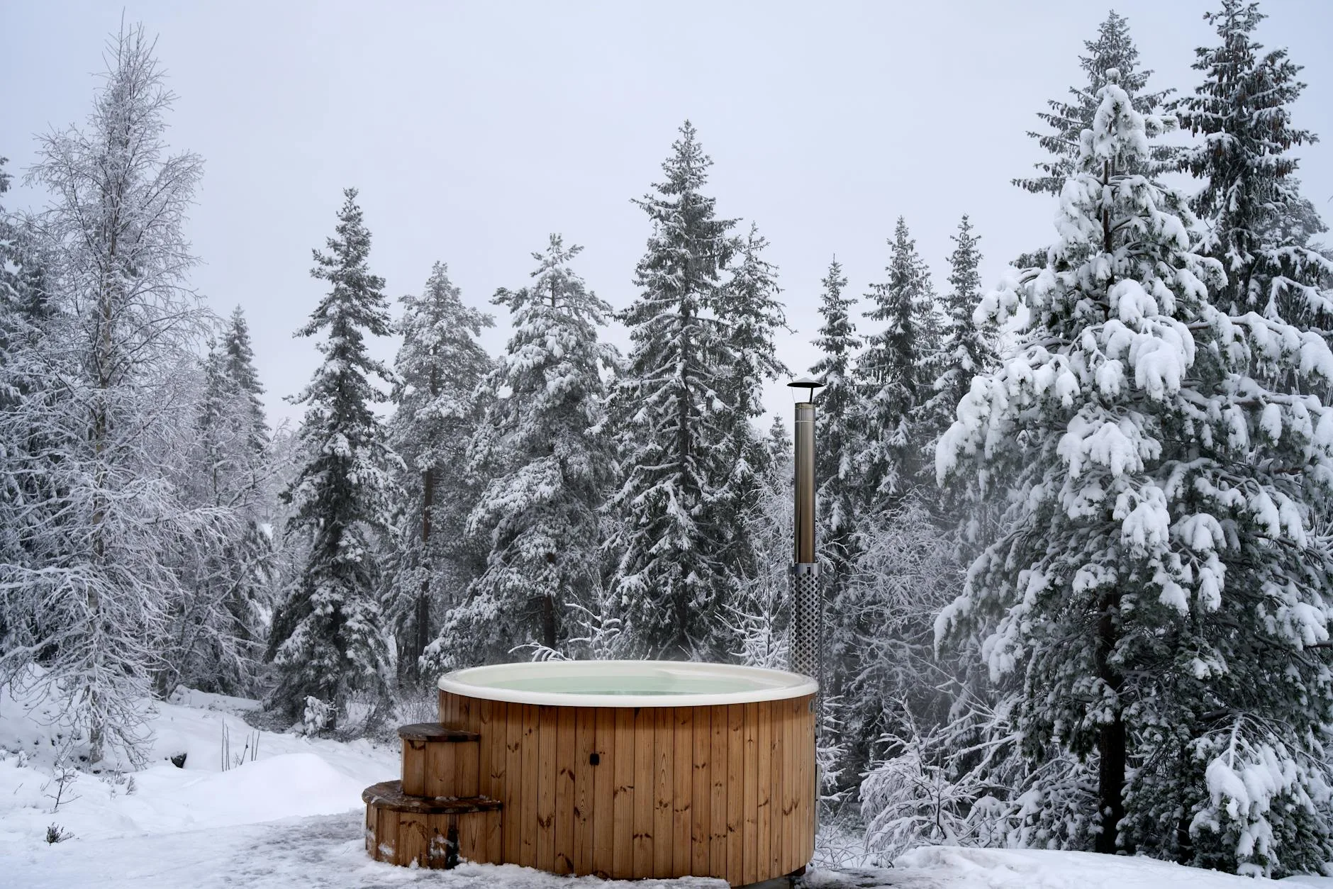 Hot tub on a wooden deck in a winter garden setting