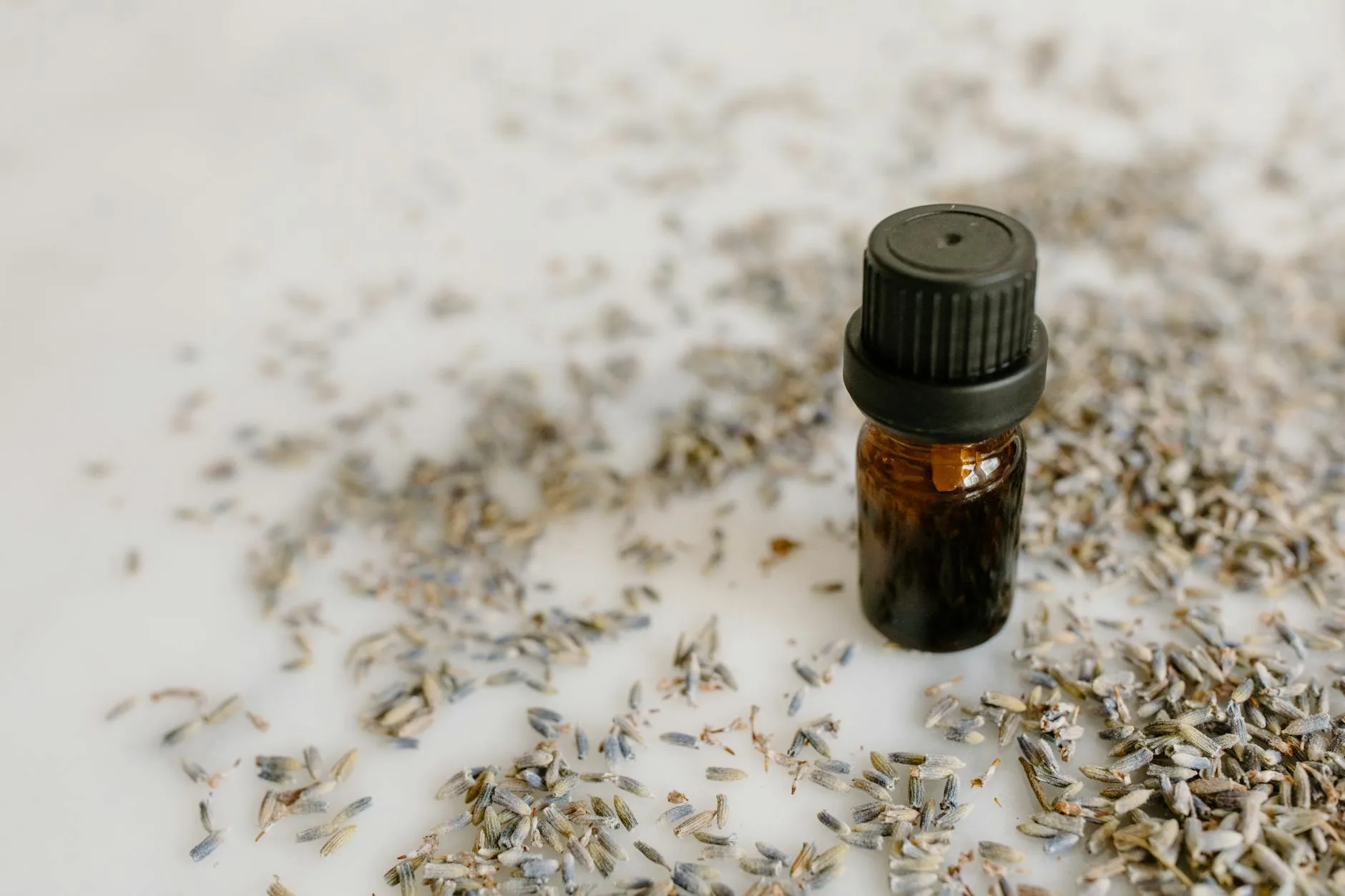 Lavender essential oil bottle with dried lavender flowers
